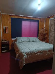 1 dormitorio con cama y ventana grande en QUELKUN, FAMILIAR, en Quellón