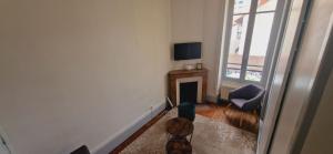 Una sala de estar con chimenea y televisión. en MINSHUKU, en Chalon-sur-Saône