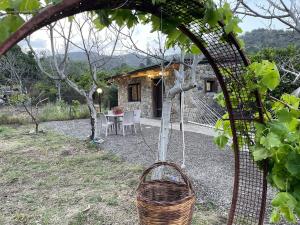 un jardin avec une table et des chaises et un bâtiment dans l'établissement Sicily Stone Cottage, à Graniti