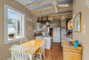 eine Küche und ein Esszimmer mit einem Holztisch und Stühlen in der Unterkunft Scuttlebutt Nautical Cottage in Beaufort