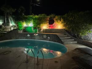 una piscina en un patio por la noche en Lua Nova Ferradurinha Buzios, en Búzios