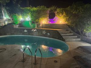 una piscina con luces en un patio por la noche en Lua Nova Ferradurinha Buzios, en Búzios