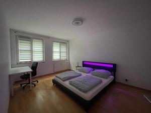 Schlafzimmer mit einem Bett, einem Schreibtisch und Fenstern in der Unterkunft Charmante 3-Zimmer-Wohnung Zentral in Wiesbaden in Wiesbaden