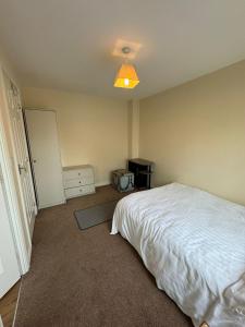1 dormitorio con cama blanca y luz en Double rooms, en Milton