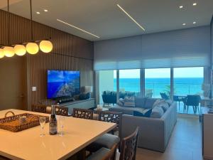María Chiquita的住宿－Delux Oceanview on the Caribbean @ Playa Escondida Resort，客厅配有沙发和带酒杯的桌子