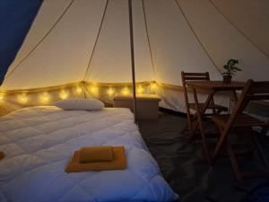 - une chambre avec une tente dotée d'un lit et d'une table dans l'établissement Bearsu Nature Almoxarife, à Horta