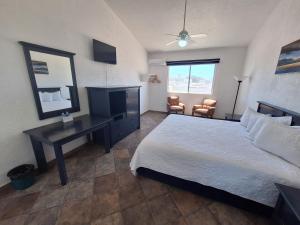 a bedroom with a bed and a desk and a mirror at Playa Inn Rocky Point in Puerto Peñasco