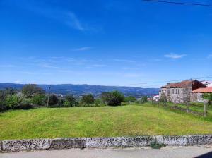 a view of a field of grass with a house at Casa da Martha in Celorico da Beira
