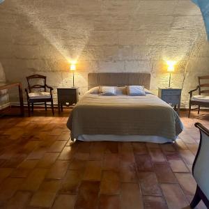 モサーヌ・レ・ザルピイユにあるMoulin des Calansのベッドルーム1室(ベッド1台、椅子2脚付)