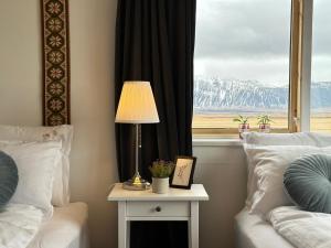 a bed room with a table with a lamp and a window at Selið Farm Stay - Guesthouse 