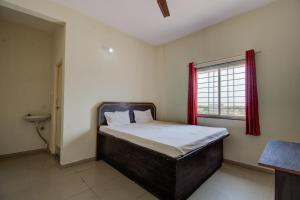 - une petite chambre avec un lit et une fenêtre dans l'établissement SPOT ON San Tower Hotel, à Kilimanūr