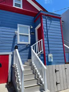 サンフランシスコにあるQuesada Homestayの赤いドアと階段のある青い家