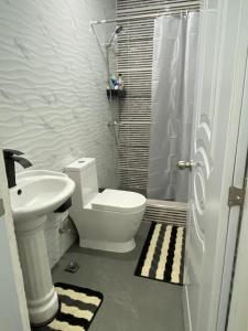 a bathroom with a toilet and a sink at Merengue House in Boca Chica