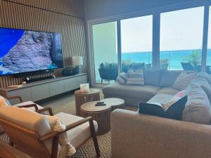 a living room with a couch and a flat screen tv at Delux Oceanview on the Caribbean @ Playa Escondida Resort in María Chiquita