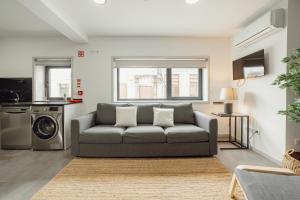 a living room with a couch and a washing machine at Amazing Villa by Hosty in Porto