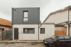 a black car parked in front of a house at Amazing Villa by Hosty in Porto