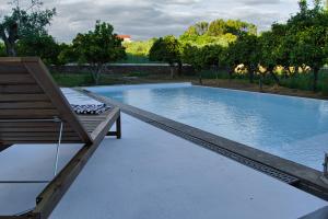 basen z ławką obok basenu w obiekcie Monte Alecrim w mieście Alandroal
