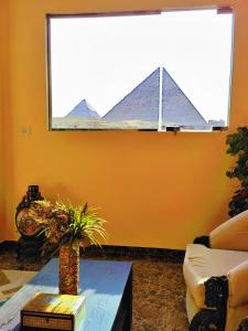 een woonkamer met uitzicht op de piramides bij Energy Of Pyramid Hotel in Caïro