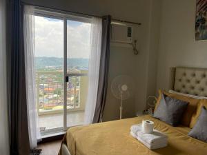 a bedroom with a bed and a large window at Verdon Parc Davao City with Balcony by darpm in Davao City