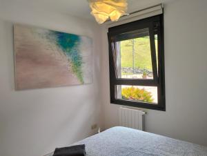 a bedroom with a window and a painting on the wall at Prim 9 izquierda in Bilbao