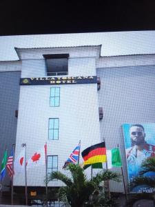 a white building with flags in front of it at Villa toscana Victoria island oniru in Lagos
