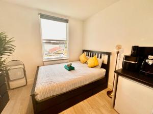 a bedroom with a bed with a teddy bear on it at Lovely self contained studio now available in London