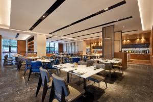 a restaurant with tables and chairs and a bar at Fairfield by Marriott Guangzhou Konggang in Guangzhou