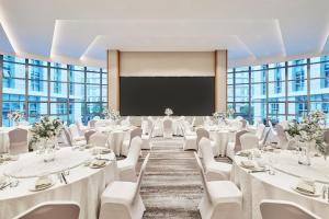 a conference room with tables and chairs and a projection screen at Fairfield by Marriott Guangzhou Konggang in Guangzhou