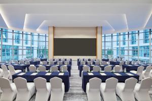 einen Konferenzraum mit Stühlen und einer Leinwand in der Unterkunft Fairfield by Marriott Guangzhou Konggang in Guangzhou