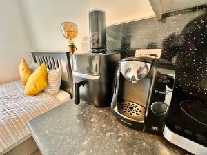 Lovely self contained studio now available في لندن: مطبخ مع آلة صنع القهوة على منضدة