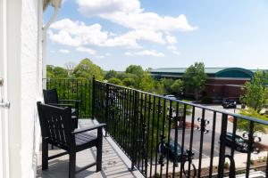 a balcony with two chairs and a view of a parking lot at The Harvey in New Bern