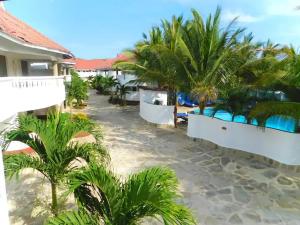 a resort with palm trees and a swimming pool at Bedroom Diani Beach in Diani Beach