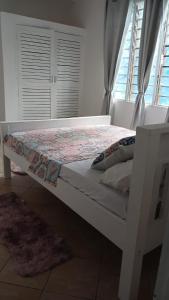 ein weißes Bett in einem Zimmer mit Fenster in der Unterkunft Bedroom Diani Beach in Diani Beach