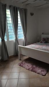 Schlafzimmer mit einem Bett und einem Fenster mit Vorhängen in der Unterkunft Bedroom Diani Beach in Diani Beach