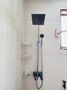 a shower with a shower head in a bathroom at Urban Haven Rooms in Iringa