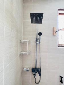 a shower with a shower head in a bathroom at Urban Haven Rooms in Iringa +30 photos