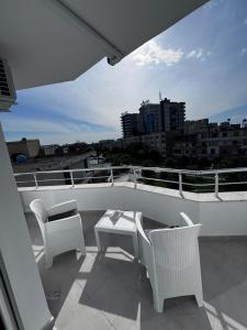a balcony with chairs and a table and a view of a city at Prime Luxury Apartments in Lushnjë