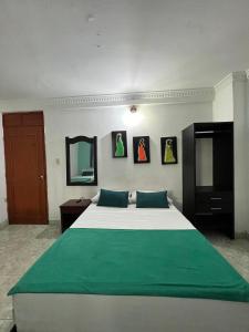 a bedroom with a large bed with green sheets at Hotel Coco Beach in Santa Marta