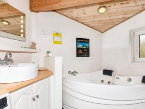 un bagno bianco con vasca e lavandino di 6 person holiday home in Vestervig a Vestervig