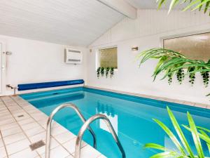 a swimming pool in a house with a blue swimming pool at Holiday home Øster Assels III in Øster Assels