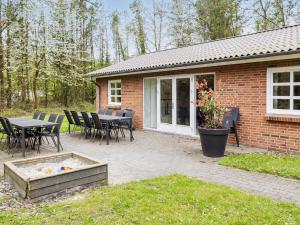 a patio with a table and chairs in front of a house at Holiday home Øster Assels III in Øster Assels