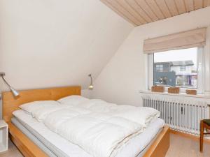 a large white bed in a room with a window at Holiday home Vestervig XLIX in Vestervig