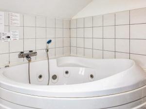 y baño de azulejos blancos con bañera blanca. en 8 person holiday home in Vestervig en Vestervig