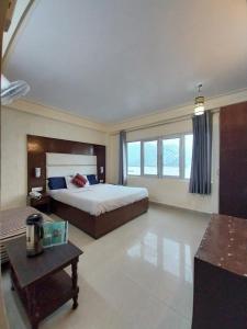 a large bedroom with a bed and a table at Hotel Mussoorie International in Mussoorie