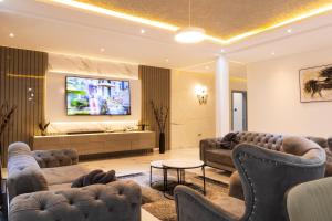 a living room with couches and a flat screen tv at 5 Bedrooms Luxury Vacation Villa in Accra