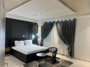 a bedroom with a bed and a table and a chair at 5 Bedrooms Luxury Vacation Villa in Accra +42 photos