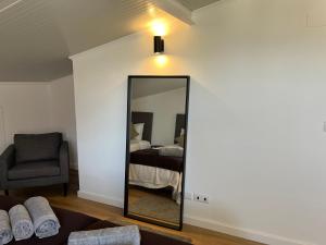 a mirror in a room with a bed and a chair at Bairro Alto - Apartamento in Lisbon