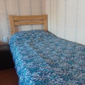un letto con piumone blu in una camera da letto di SN - Departamento 2 ambientes Sin cocina - Serena Alojamientos a San Nicolás de los Arroyos