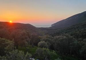 una puesta de sol sobre un valle con árboles y montañas en Villa Tramonto D'Oro en Ulcinj