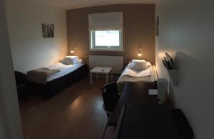 um pequeno quarto com 2 camas e uma janela em Hotel E-10 em Kiruna